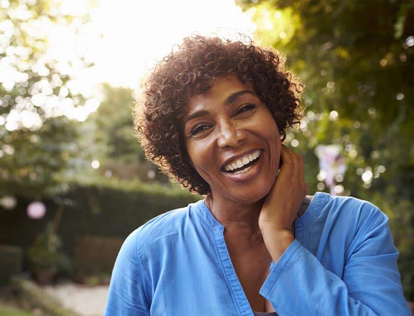 Woman standing outside and looking into the camera smiling