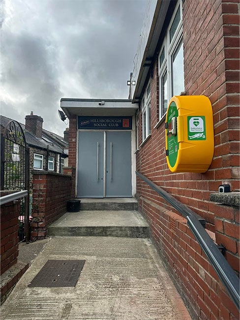 The Hillsborough Social Club with a defibrillator donated by Westfield Health
